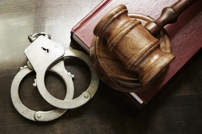 A stock photo of handcuffs and a gavel.